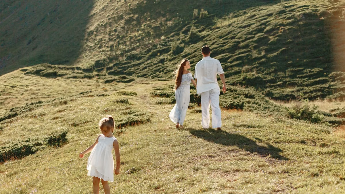 A family enjoys a sunny day on a grassy hillside, capturing the essence of outdoor leisure and connection.
